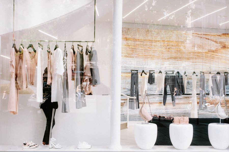 Row of garments on wooden hangers in a boutique