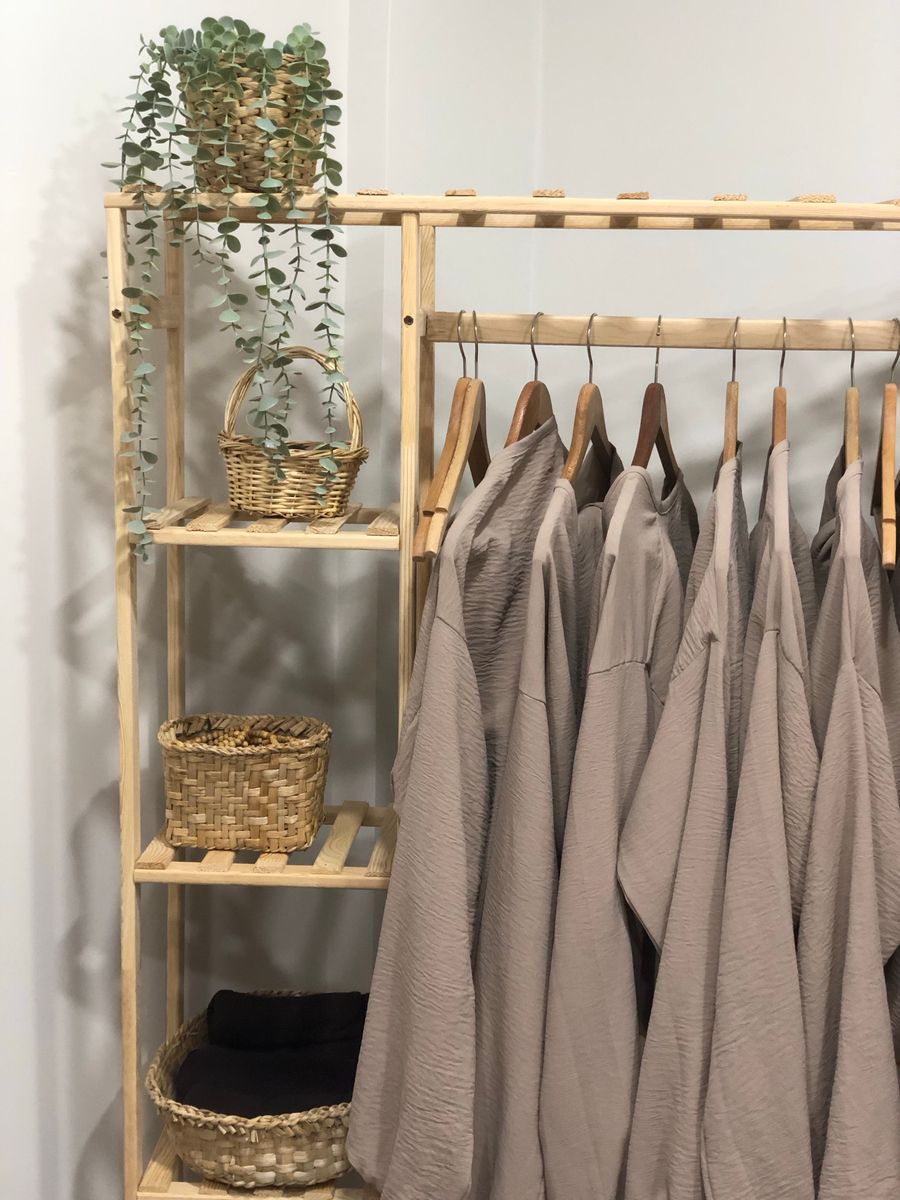 Wooden rack with linen clothes and woven baskets